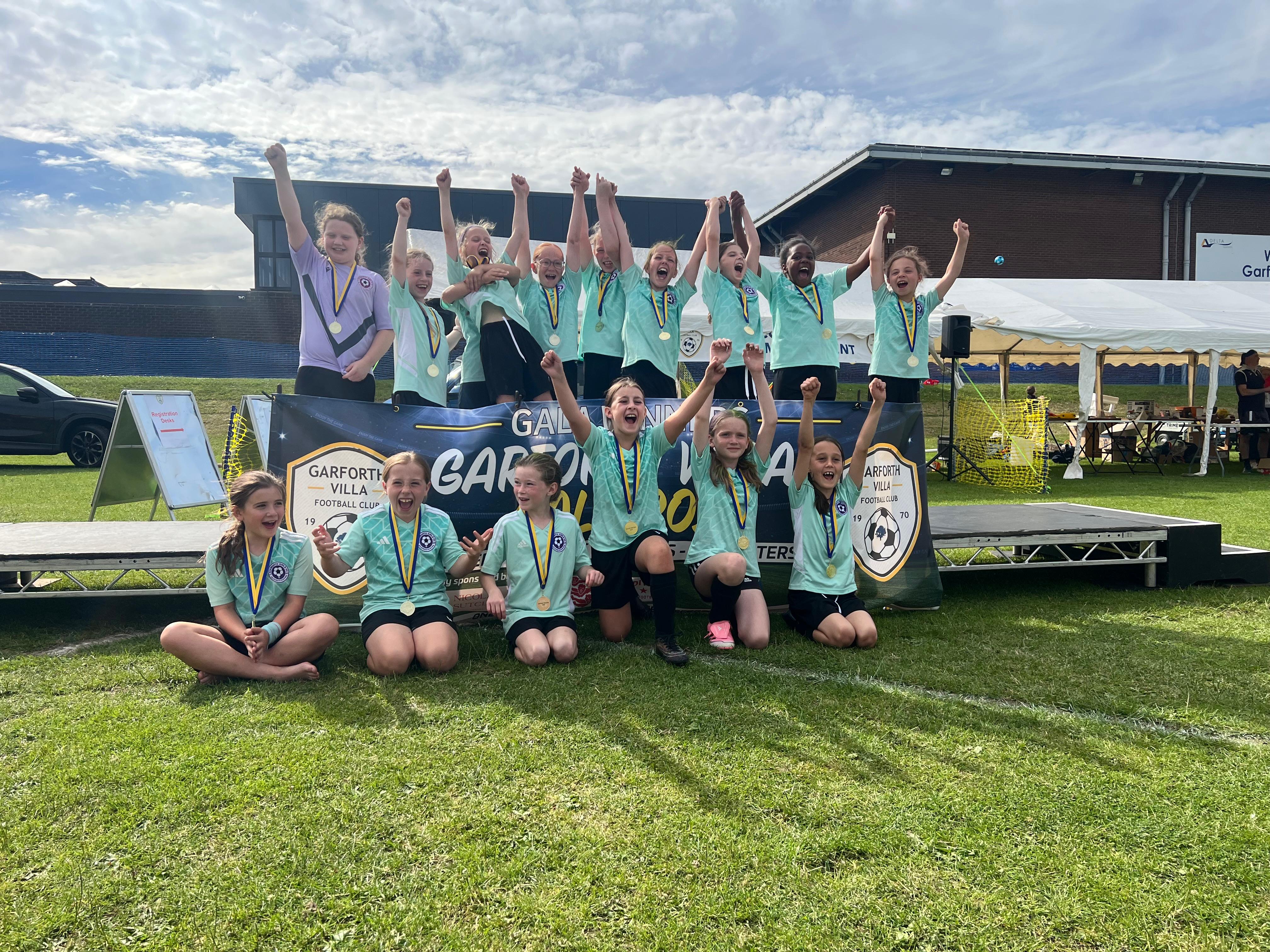 Ackworth Girls FC players celebrating with their medals